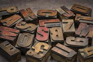 alphabet abstract in vintage letterpress wood type printing blocks, mirror image, against handmade bark paper photo