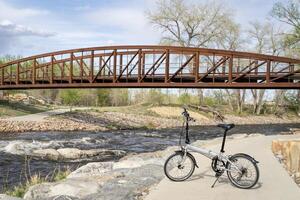 lightweight folding bike at whitewater park on the Poudre River in downtown of Fort Collins, Colorado, spring scenery photo