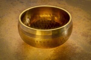 tibetan singing bowl on a backlit leather surface, sound therapy for healing, relaxation and meditation photo