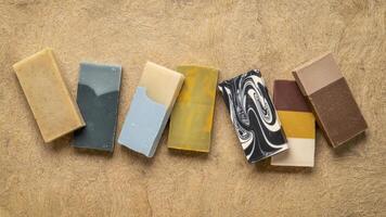 variety of 7 organic, artisan soap bars on a textured bark paper photo