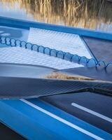 wet paddle and a coiled safety leash on a deck of stand up paddleboard photo