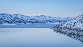 winter dusk over partially frozen Horsetooth Reservoir at foothills of northern Colorado photo