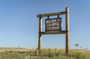 Bienvenido a vistoso Colorado borde del camino de madera firmar a un frontera con Nebraska en oriental Colorado foto