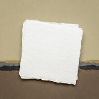 small square sheet of blank white Khadi paper against abstract in earth tones photo