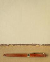abstract paper landscape in pastel earth tones tones - collection of handmade rag papers with a wooden luxury pen photo