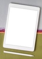 mockup of digital tablet with electronic pencil and a blank isolated screen, clipping path included, against aabstract paper landscape photo