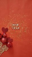 Navidad flatley con nuevo año letras en rojo oro antecedentes adornos decoración. de cerca, brillante composición. tarjeta postal . vertical foto