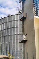 Cropped photo of part of a metal steel container for long term grain storage. Giant tanks with crop for preserving. Closeup.