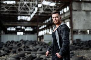 Attractive young man with tires at the background. Attractive elegant serious man looking at the camera. Selective focus photo