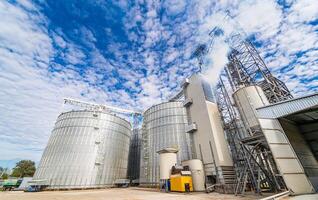 Tanks and agricultural silos of grain elevator storage. Loading facility building exterior. View from below. photo