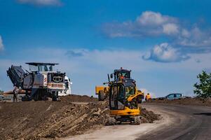 An excavator in a road construction site. Yellow special technic, machinery. Road repair concept. photo