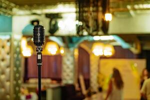 Retro style of microphone on restaurant background. Vintage professional musical equipment. photo