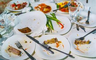 Empty dishes after family dinner in restaurant. Party, celebration or healthy food concept. photo
