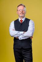 Confident senior man in shirt. Crossed arms on chest. Yellow background. Horizontal half length photo. Vertical photo. photo