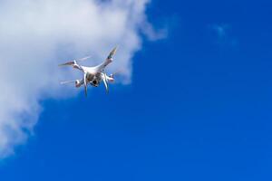 quadrocopter volador en el cielo. moderno dron en el aire con cámara. foto