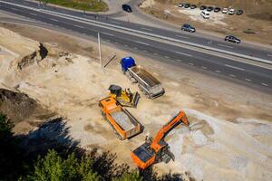 aéreo ver de pesado maquinaria para aplastante y coleccionar piedra, caliza, arena y grava, materiales para asfalto productores y pavimentación camino, construcción. foto