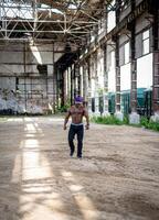 Muscular young man going outside. Strong muscle bodybuilder with naked torso posing for camera. photo