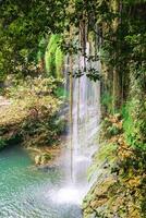 Panorama of Kursunlu waterfall with clear water in the lake. View of Kursunlu Waterfall in Antalya, flowing from high mountain. photo