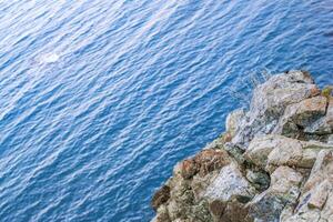 Tranquil scene with azure waters and unique rock formations. High cliff near to sea. photo