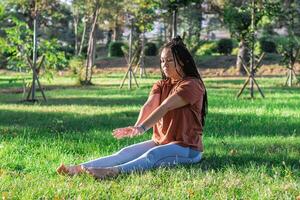 mujer es haciendo yoga asana fuera de en un parque. concepto de equilibrio y sano estilo de vida. foto