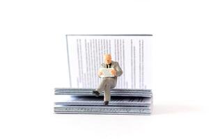 mundo libro día concepto, miniatura personas mayor chico leyendo un libro solo foto