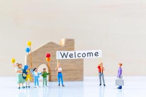 Miniature people holding Welcome signs at front of the home photo