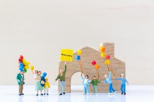 Miniature people holding Welcome signs at front of the home photo