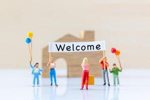 Miniature people holding Welcome signs at front of the home photo