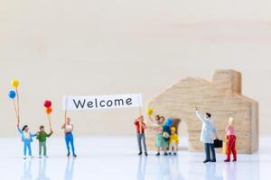 Miniature people holding Welcome signs at front of the home photo