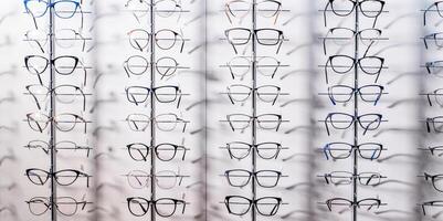 Raw of fashion elegance glasses in the store. Showcase with glasses in modern ophthalmic store. Closeup. photo