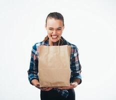 Young woman with brown paper bag. Emotion of surprise. Taking or giving gift. Celebration concept. photo