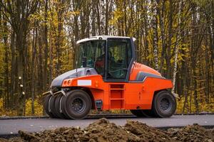 Pavement truck. Laying fresh asphalt on construction site. Heavy machine industry. Mechanical engineering. photo