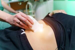 Doctor makes abdominal ultrasound to a patient. Medical research. Selective focus. Close-up. photo