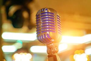 Close up of microphone on stage at outdoor night party, abstract bokeh light background photo
