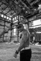 muscular joven carrocero con desnudo torso posando para cámara. fuerte musculoso hombre posando sin camisa. foto