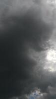 Grey cumulus clouds covering the sky. Dull cloudscape gathering for rain. Low angle view timelapse. Vertical video