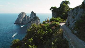 ikonisch faraglioni Felsen angesehen von ein Wandern Weg auf Capri. ein einsam Beobachter Frau nimmt im das Pracht von das hoch aufragend Meer Stapel, malerisch Meereslandschaft. video