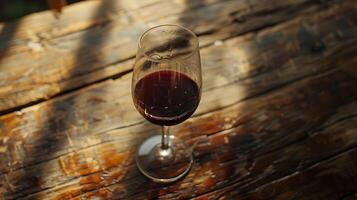 AI generated Red Wine Glass on Rustic Table Bathed in Soft Natural Light photo