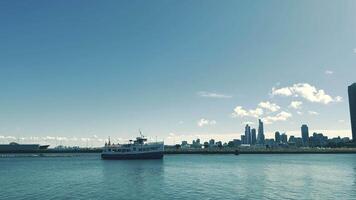 Fähre Boot im städtisch direkt am Wasser Chicago Illinois. ein Fähre Boot Segel entlang das direkt am Wasser mit ein Stadt Horizont im das Hintergrund. video