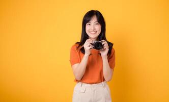 Excited asian woman traveler capturing her holiday memories with a camera and backpack. Adventure concept. photo