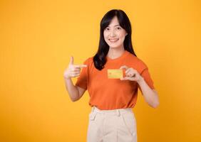 Confident young woman 30s showcasing a happy smile while holding a credit card, representing successful online shopping and secure payment transactions. photo