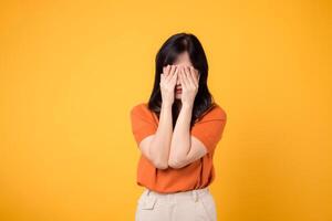 Sad young woman isolated on yellow background, reflecting inner confusion and anxiety. Expressive portrait of upset emotions concept. photo