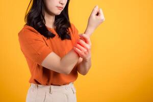 Isolated portrait of a girl touching her wrist in discomfort. Illustrating pain and inflammation due to injury. photo