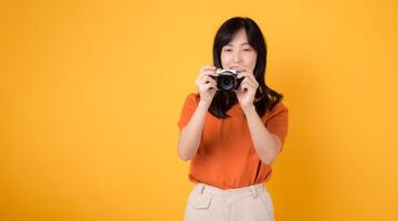 emocionado asiático mujer 30s viajero capturar su fiesta recuerdos con un cámara y mochila. aventuras concepto. foto