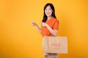 Happy asian shopper with bags, posing with a joyful gesture, capturing the thrill of fashion and discounts. photo