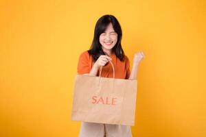 Experience the love and excitement of a surprising shopping spree with the best deals. Trendy woman presents her stylish finds, embodying the spirit of happiness. isolated on yellow background photo