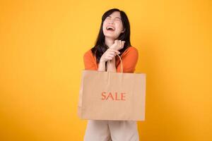 Discover the excitement of surprising deals and joyful shopping. Trendy woman holds bags, embodying the happiness of finding the ultimate discounts. isolated on yellow background. photo