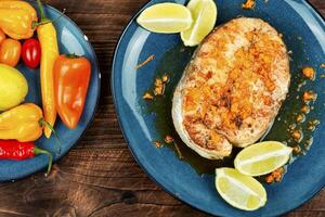 Fried salmon steak on wooden table photo