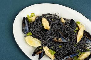 Black pasta with mussels and clams. photo