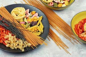 Collection of different raw pasta on table. photo